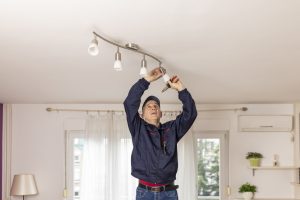 man changing a ceiling energy saving light